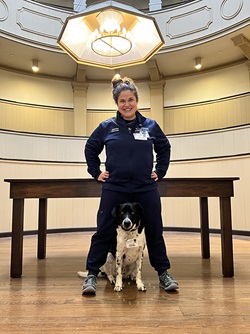 Michelle Bass stands next to therapy dog Norman in Pennsylvania Hospital’s surgical amphitheater.